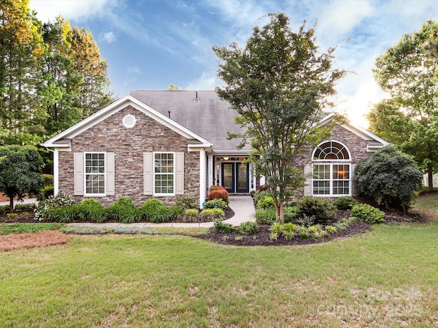 ranch-style home featuring stone siding and a front lawn