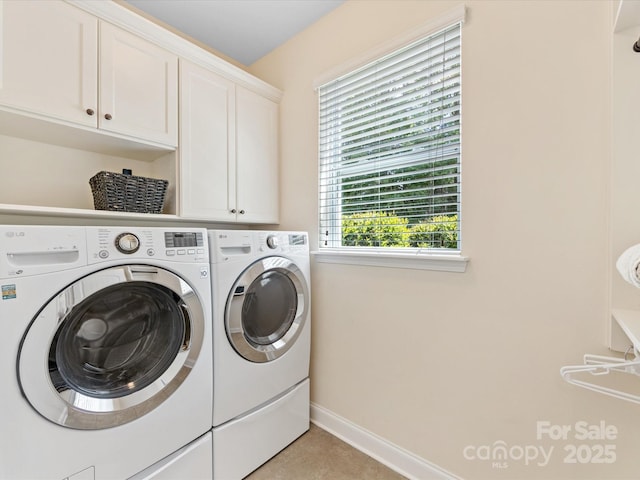 laundry room with cabinet space, washer and dryer, and baseboards