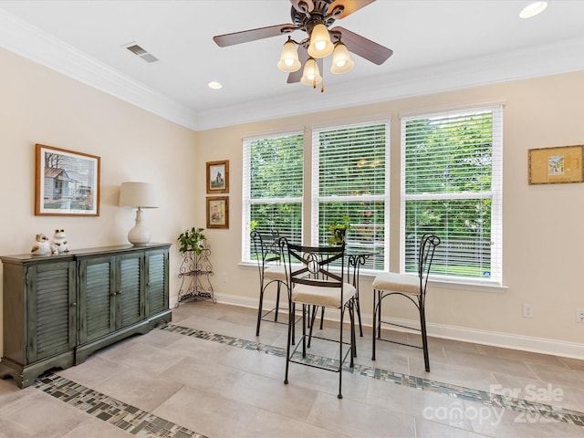 dining space with light tile patterned floors, visible vents, baseboards, ceiling fan, and ornamental molding