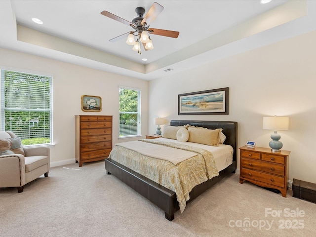 bedroom featuring baseboards, light carpet, a tray ceiling, and recessed lighting