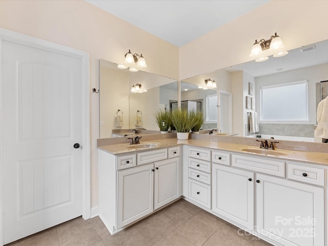 bathroom featuring tile patterned floors, visible vents, a sink, and double vanity