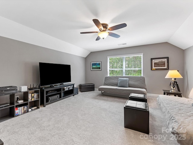 carpeted living room with lofted ceiling, baseboards, visible vents, and ceiling fan