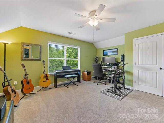 carpeted home office featuring visible vents, baseboards, lofted ceiling, and ceiling fan