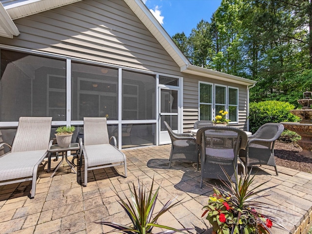 view of patio / terrace with outdoor dining space and a sunroom