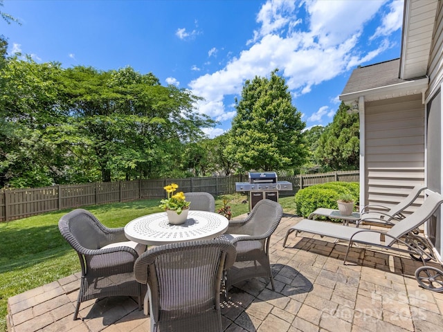 view of patio with a grill, a fenced backyard, and outdoor dining space
