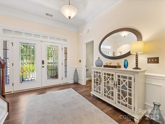 foyer entrance featuring french doors, dark wood finished floors, visible vents, wainscoting, and ornamental molding
