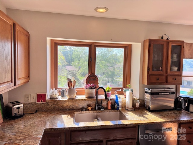 5A Hedgerose Ct, Asheville, NC 28805 - kitchen featuring stainless steel dishwasher, light stone countertops, glass insert cabinets, and a sink