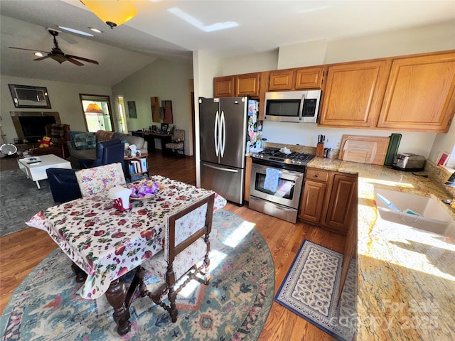 5A Hedgerose Ct, Asheville, NC 28805 - kitchen with ceiling fan, a sink, light wood finished floors, appliances with stainless steel finishes, and vaulted ceiling