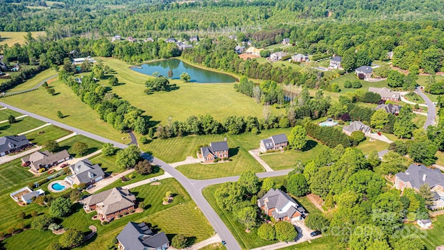 drone / aerial view featuring a water view, a residential view, and a forest view