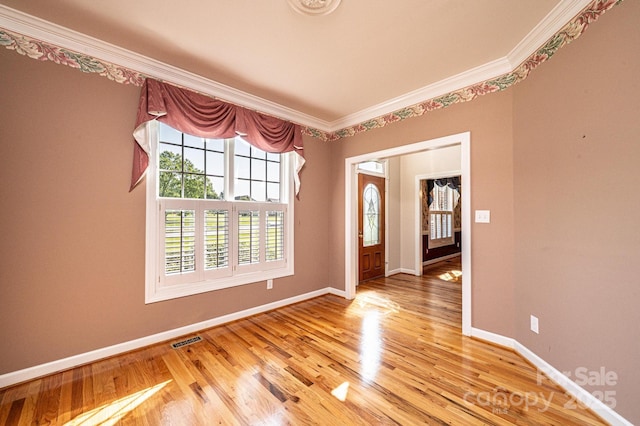 foyer entrance featuring baseboards, visible vents, and ornamental molding