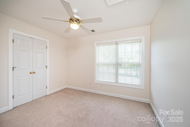 unfurnished bedroom with baseboards, light colored carpet, and a closet