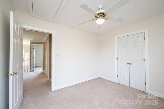 unfurnished bedroom featuring baseboards, a ceiling fan, a closet, and light carpet