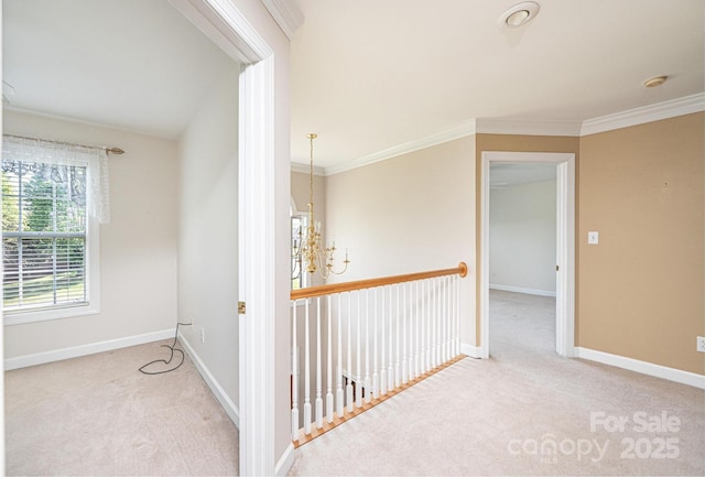 hall featuring baseboards, ornamental molding, and carpet