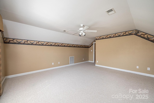 additional living space with a ceiling fan, baseboards, visible vents, and vaulted ceiling