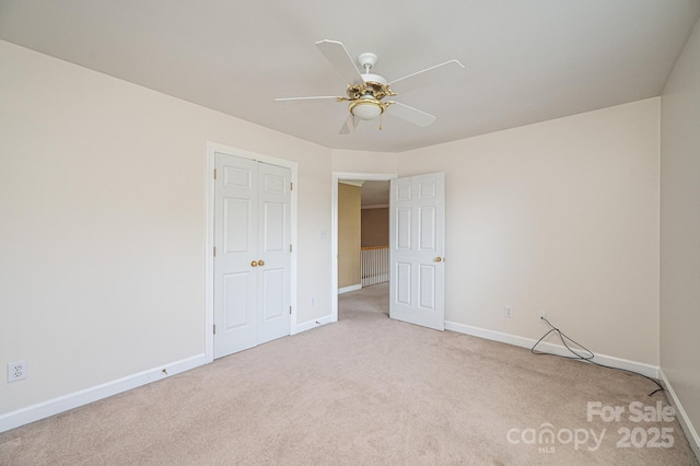 unfurnished bedroom with a ceiling fan, baseboards, and light colored carpet