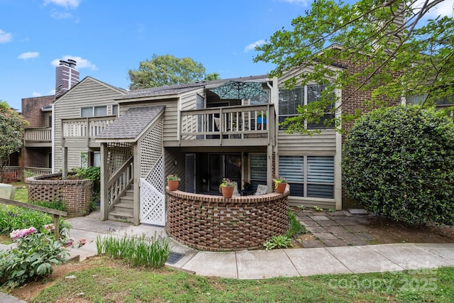 rear view of house with a wooden deck, a patio, and stairs