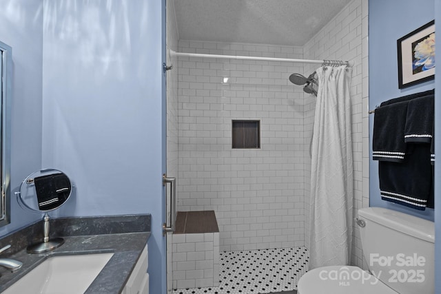 full bathroom featuring vanity, a textured ceiling, toilet, and a shower stall