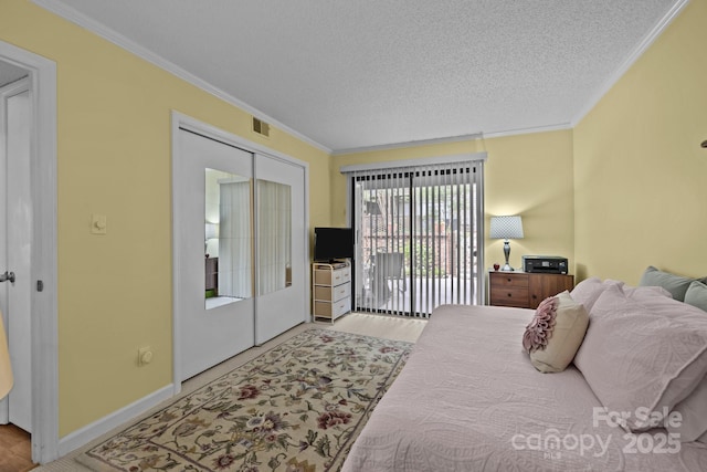 bedroom with crown molding, a textured ceiling, access to exterior, baseboards, and visible vents