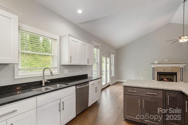 76 Tryon View Dr, Flat Rock, NC 28731 - kitchen with white cabinets, a sink, dark stone countertops, stainless steel dishwasher, and vaulted ceiling