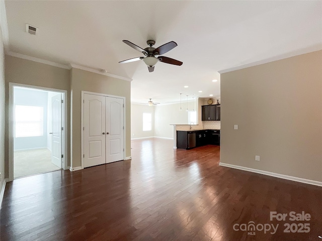 unfurnished living room featuring crown molding, dark wood-style flooring, ceiling fan, baseboards, and visible vents