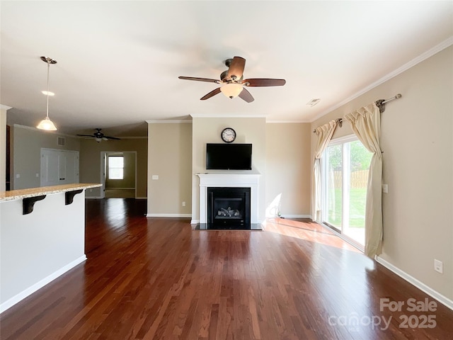 unfurnished living room featuring ornamental molding, a ceiling fan, and a wealth of natural light
