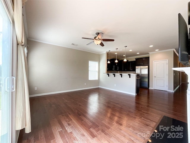 unfurnished living room with crown molding, a ceiling fan, and baseboards