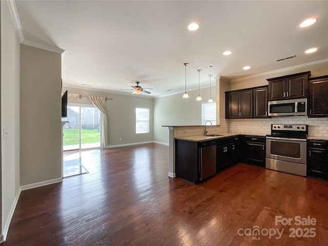 kitchen with ornamental molding, ceiling fan, a sink, appliances with stainless steel finishes, and backsplash