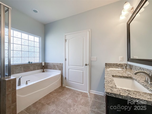 bathroom with a sink, tile patterned flooring, a garden tub, and double vanity