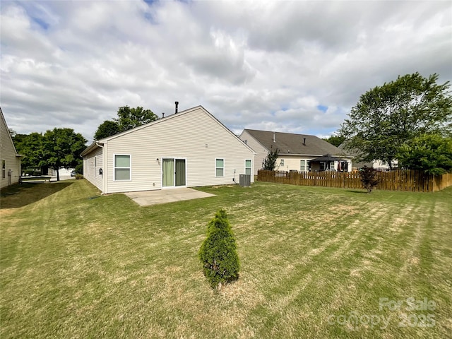 rear view of property featuring a patio, central AC, fence, and a yard