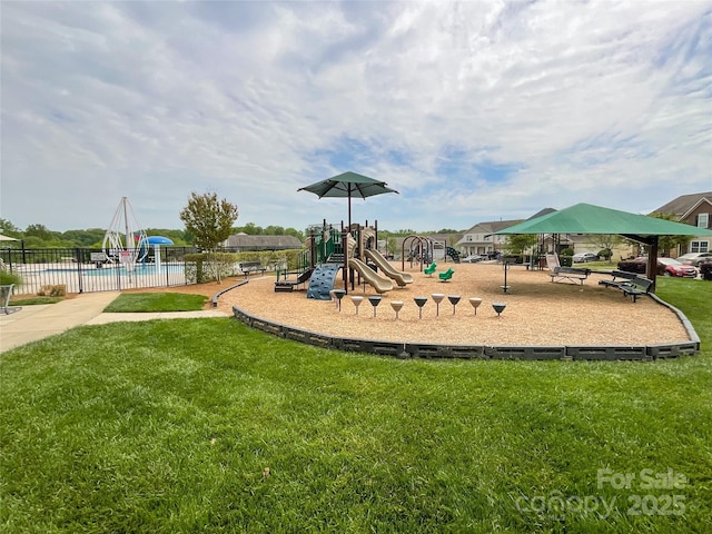 community playground featuring fence, a community pool, and a yard