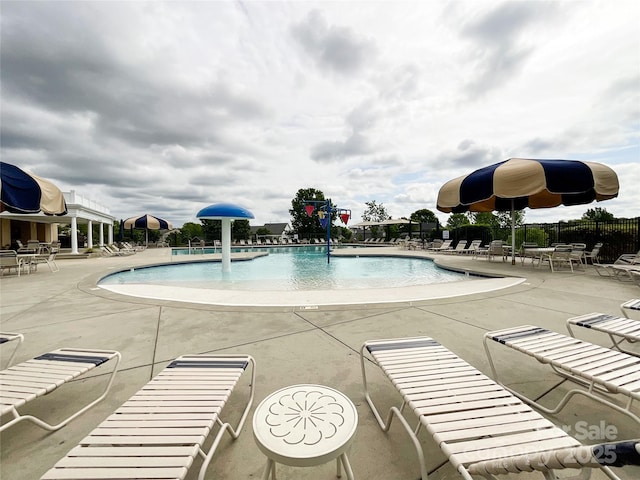 community pool with fence and a patio