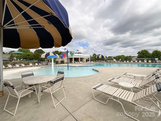 community pool featuring fence and a patio area