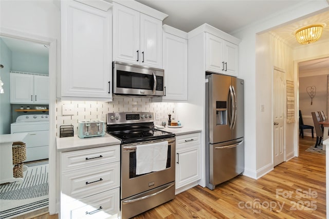 7700 Ninth Fairway Ln, Mint Hill, NC 28227 - kitchen featuring light wood finished floors, light countertops, washer / clothes dryer, stainless steel appliances, and backsplash
