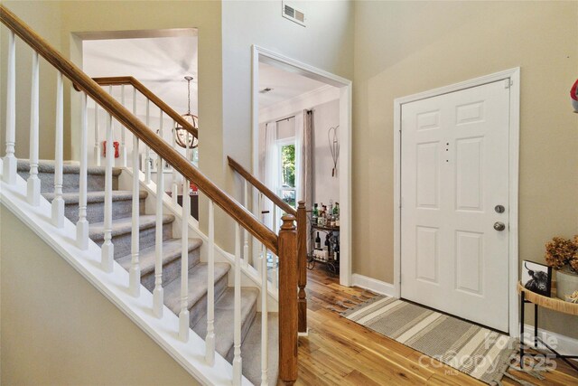 7700 Ninth Fairway Ln, Mint Hill, NC 28227 - entryway featuring visible vents, light wood finished floors, a notable chandelier, and stairway