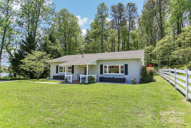 ranch-style house with fence and a front yard