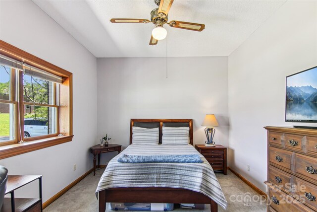 bedroom with baseboards, ceiling fan, and light carpet