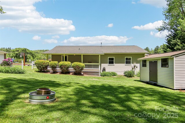 back of house with a lawn, an outbuilding, and a storage shed