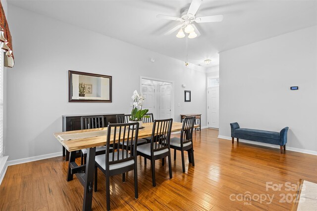 dining area featuring baseboards, a ceiling fan, and wood finished floors