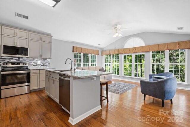 kitchen featuring a healthy amount of sunlight, visible vents, appliances with stainless steel finishes, wood finished floors, and a sink