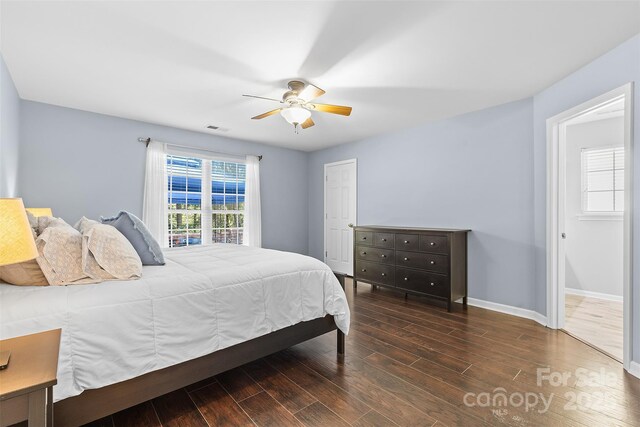 bedroom featuring baseboards, a ceiling fan, wood finished floors, and visible vents