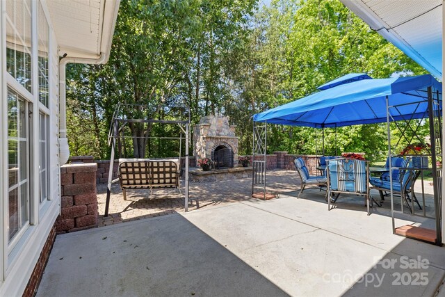 view of patio / terrace featuring an outdoor stone fireplace and outdoor dining space