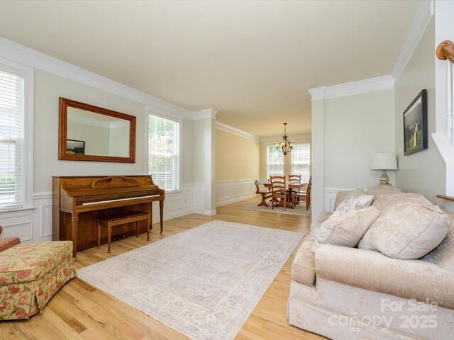 10944 Persimmon Creek Dr, Mint Hill, NC 28227 - living area featuring crown molding, wainscoting, wood finished floors, a chandelier, and a decorative wall