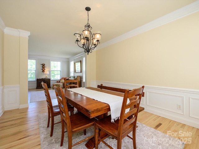 10944 Persimmon Creek Dr, Mint Hill, NC 28227 - dining room featuring crown molding, wainscoting, a decorative wall, a chandelier, and light wood finished floors