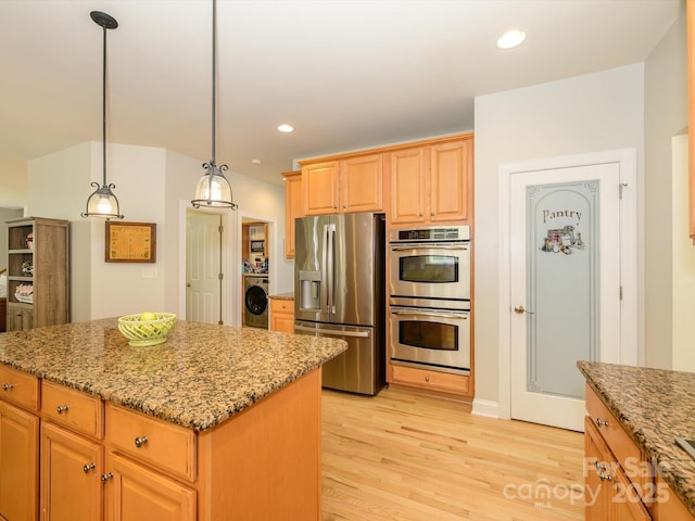 10944 Persimmon Creek Dr, Mint Hill, NC 28227 - kitchen with stainless steel appliances, washer / dryer, light stone counters, and a center island