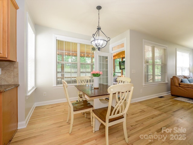 10944 Persimmon Creek Dr, Mint Hill, NC 28227 - dining space with light wood-style floors, baseboards, a notable chandelier, and a healthy amount of sunlight