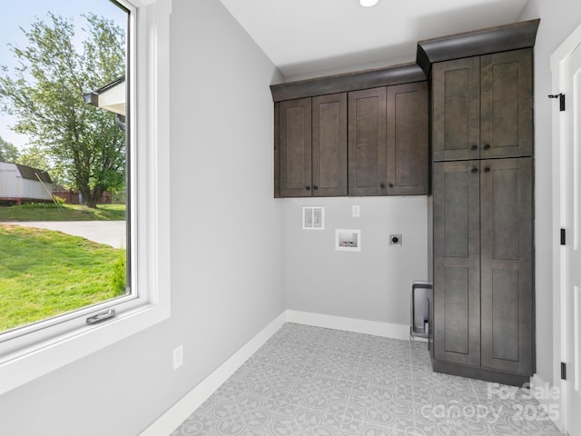 washroom featuring cabinet space, a wealth of natural light, baseboards, and electric dryer hookup