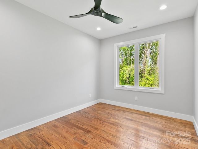 spare room with baseboards, ceiling fan, and wood finished floors
