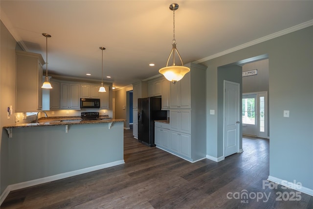 kitchen featuring black appliances, a peninsula, dark stone counters, crown molding, and a breakfast bar