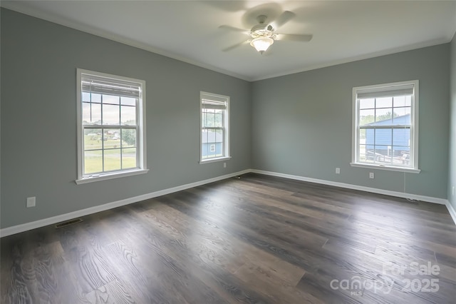 unfurnished room featuring healthy amount of natural light, ceiling fan, baseboards, dark wood-type flooring, and ornamental molding