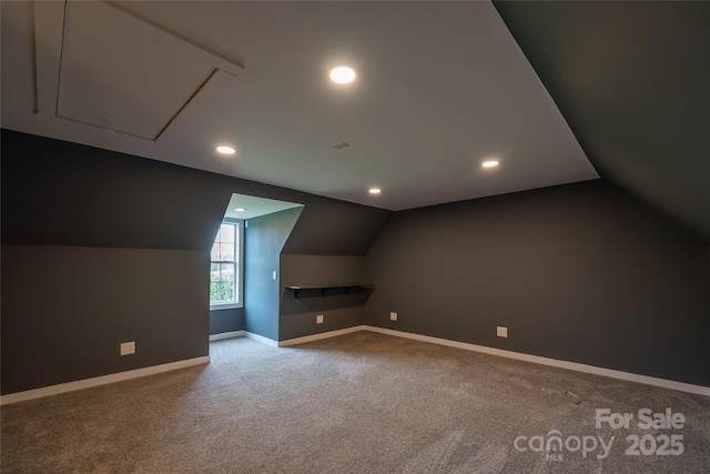 additional living space with lofted ceiling, carpet, baseboards, recessed lighting, and attic access